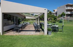 a patio with tables and chairs under a white canopy at Atrion Resort Hotel in Agia Marina Nea Kydonias