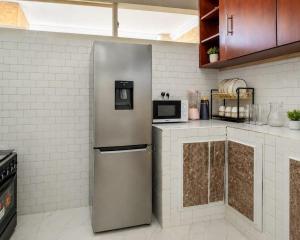 a kitchen with a stainless steel refrigerator at City Getaway Apartment in Zanzibar City