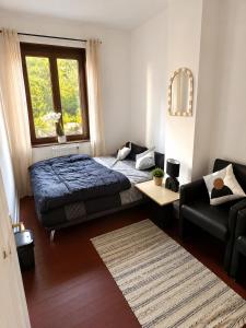 a bedroom with a bed and a couch and a window at Maison Traversière in Long de Bout