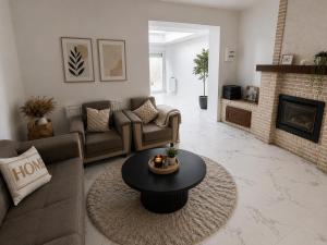 a living room with a couch and a table at Maison Traversière in Long de Bout