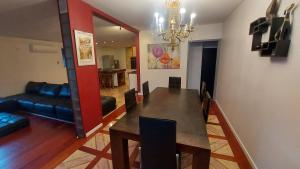 a dining room with a table and a couch at Maison élégante à Saint-Pierre + Piscine in Casabona