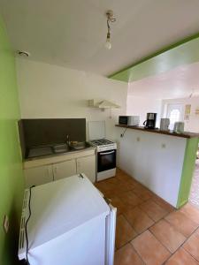a kitchen with a stove and a white refrigerator at Maison chaleureuse à Audignies avec stationnement privé in Audignies