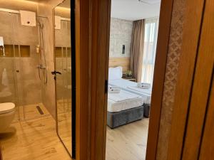 a room with a bed and a shower and a bathroom at Хотел Камъните in Burgas +160 photos