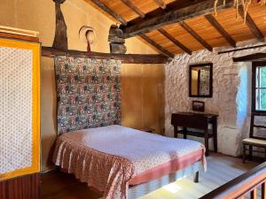 a bedroom with a bed and a table in a room at Maison charmante à Valleraugue avec piscine partagée. in Valleraugue