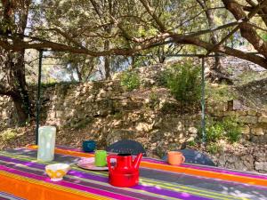 a colorful table with plates and cups on it at Maison charmante à Valleraugue avec piscine partagée. in Valleraugue +14 photos