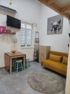 a living room with a yellow couch and a table at Tiny House Faro in Faro