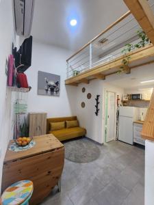 a living room with a couch and a loft at Tiny House Faro in Faro