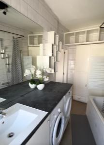 a white kitchen with a sink and a washing machine at la casa de gege in Mellet