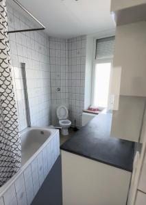 a white bathroom with a tub and a toilet at la casa de gege in Mellet