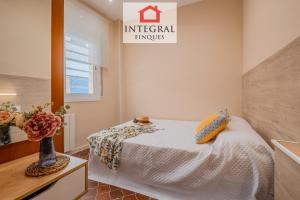 a bedroom with a bed and a vase of flowers at Casa Terral in Palamós