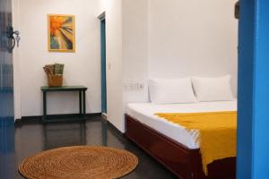 a bedroom with a bed with a rug and a table at Zen Yoga & Surf House in Arugam Bay +15 photos