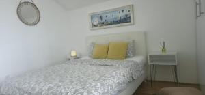 a white bedroom with a bed and a table at Fine Rest- City Center Apartment in Brčko