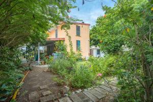 a garden in front of a house with trees at Appartement charmant au Carbet avec vue sur la mer - 50 m² in Le Carbet
