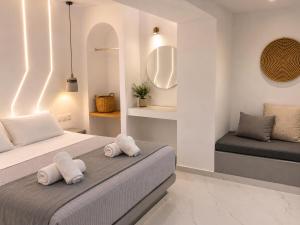 a bedroom with a bed with towels on it at Pattys Desing Suites- Private Hot Tub with yard- Fira Center in Firostefani