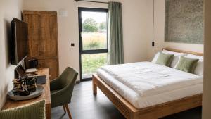 a bedroom with a bed and a desk and a window at D&C Hotel Sulingen in Sulingen