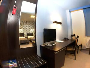 a room with a desk with a television and a mirror at Hotton Hotel in Gdynia