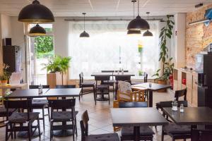 a restaurant with tables and chairs and a large window at Pension Küfner in Markkleeberg
