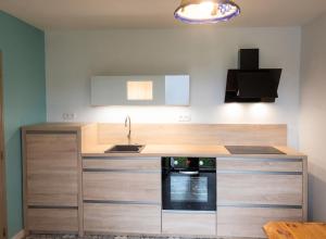 a kitchen with a sink and a stove at Appartement charmant avec vue sur lac et montagne – 75 m² in Fontrabiouse