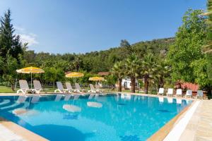 a swimming pool with chairs and umbrellas at Olympos Donkisot Pansiyon in Antalya +26 photos
