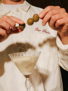 a man in a white shirt holding a olives on a drink at Florès Boutique Hotel in Zwolle +14 photos