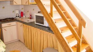 a tiny kitchen with a staircase in a tiny house at Maison charmante à Montblanc avec terrasse in Montblanc