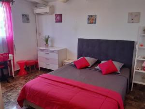 a bedroom with a large bed with red pillows at Villa élégante à Sainte-Anne avec piscine privée ouverte toute l'année in Sainte-Anne