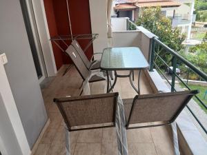 a balcony with a table and chairs on it at Aphroditi Luxury Vila in Chrysi Ammoudia