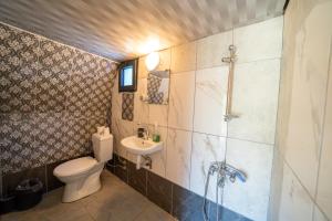 a bathroom with a toilet and a sink and a shower at Olympos Donkisot Pansiyon in Antalya
