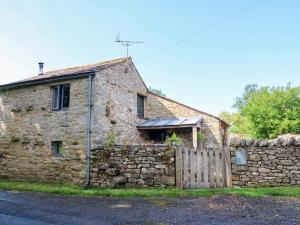 an old stone house with a wooden fence at The Brew House in Penrith