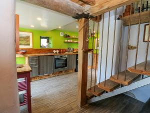 a kitchen with green walls and wooden stairs at The Brew House in Penrith