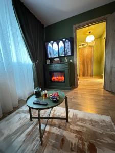 a living room with a table and a fireplace at Zara Home Cozy Studio in Petroşani