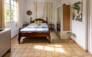 a bedroom with a bed in the middle of a room at Studio accueillant à Baie Mahault - 20 m² avec piscine privée in Baie-Mahault