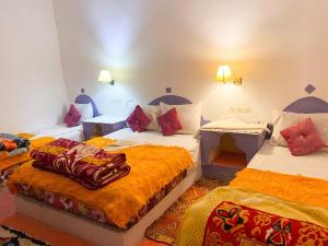 a hotel room with three beds in a room at Sumptuous Villa in Aït Ben Haddou with Private Pool in Aït Benhaddou +13 photos