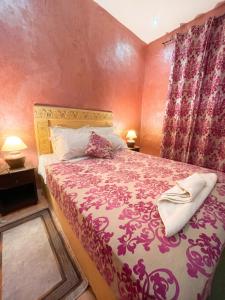 a bedroom with a large bed with pink walls at Sumptuous Villa in Aït Ben Haddou with Private Pool in Aït Benhaddou