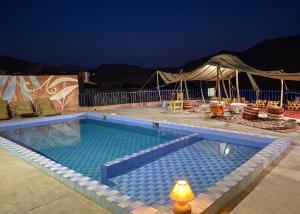 a swimming pool at night with a tent at Sumptuous Villa in Aït Ben Haddou with Private Pool in Aït Benhaddou