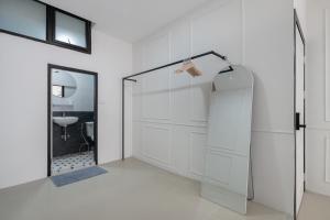 a white bathroom with a shower and a glass door at Arun Sa Wad - Chinatown House in Bangkok +123 photos