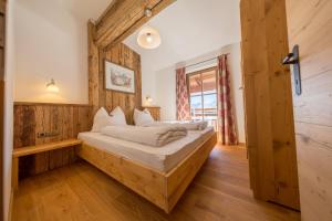 1 dormitorio con 1 cama en una habitación con paredes de madera en Ahornlodge en Mayrhofen