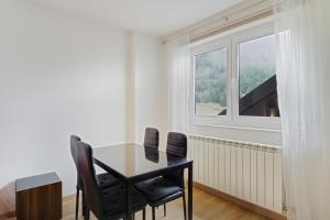a dining room table with two chairs and a window at Modern studio in Arinsal of 40 m² with mountain view in Arinsal +29 photos
