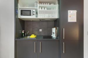 a kitchen with a sink and a microwave at Modern studio in Arinsal of 40 m² with mountain view in Arinsal