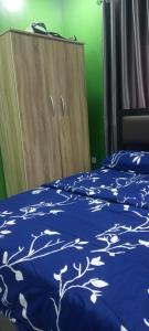 a bed with a blue comforter with trees on it at PAUL's PLACE in Loburo