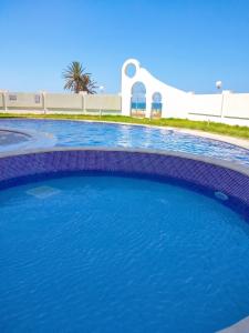 a pool with blue water in front of a building at Comfortable Apartment with Sea View – Hergla – 75 m² in Harqalah