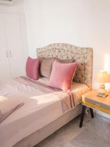 a bedroom with a bed with pink pillows on it at Comfortable Apartment with Sea View – Hergla – 75 m² in Harqalah