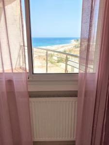 a room with a window with a view of the beach at Comfortable Apartment with Sea View – Hergla – 75 m² in Harqalah +38 photos
