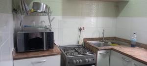 a kitchen with a microwave and a stove and a sink at PAUL's PLACE in Loburo