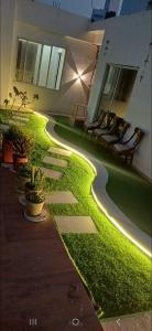 a walkway with artificial grass and lights in a building at Cube Stay in Bhopal