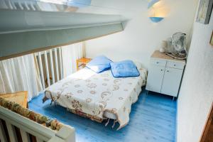 a bedroom with a bed with blue pillows on it at Maison accueillante à Leucate avec jardin et terrasse in Leucate