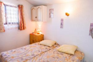 a bedroom with a bed and two pillows at Maison accueillante à Leucate avec jardin et terrasse in Leucate +22 photos