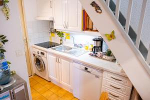 a small kitchen with white cabinets and a sink at Maison accueillante à Leucate avec jardin et terrasse in Leucate
