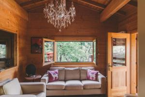 a living room with a couch and a chandelier at Cozy Chalet in Castell'Arquato 90 m² with Private Pool in CastellʼArquato