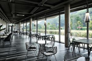 a restaurant with tables and chairs and large windows at Be,Bridge Pool Villa Resort in Yeongwol